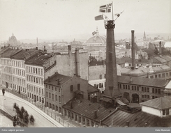 Utsikt fra Victoria Terrasse ned mot Thunes fabrikkanlegg i Ruseløkkveien ved en festlig anledning en gang rundt 1900Foto: Oslo Museum<br>