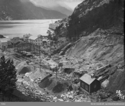 Utviding av Legeringsverket i 1915. Langs elva er stålkonstruksjonane til ein ny hall sett opp. I framgrunnen Sjoarfossen kraftstasjon, anleggsstasjonen frå 1907.Foto: NVIM I-TY0465<br>