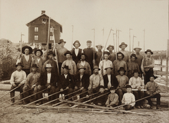 Lensearbeidere ved Fetsund 1899. Bygningen i bakgrunnen er arbeiderboligen kalt Sootbrakka. Foto: Fetsund Lenser<br>